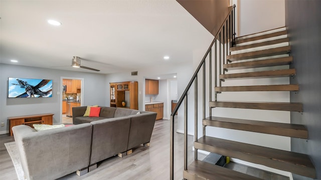 living area featuring stairs, recessed lighting, and light wood-style floors