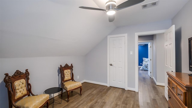 sitting room with visible vents, wood finished floors, lofted ceiling, baseboards, and ceiling fan