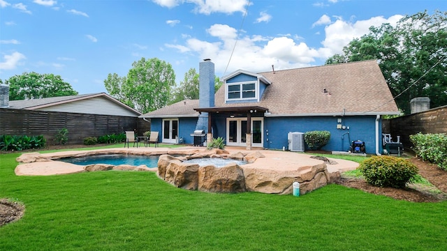 back of house with french doors, a chimney, a patio area, fence, and a yard