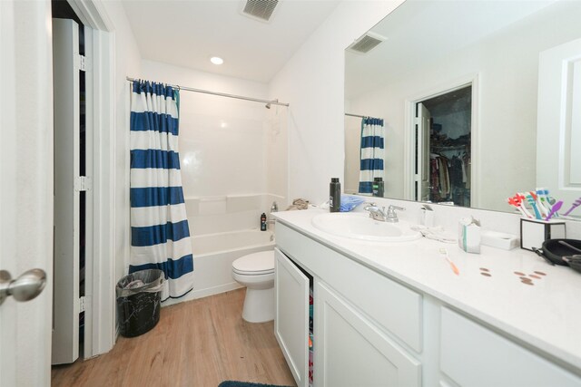 full bath with toilet, visible vents, wood finished floors, and vanity