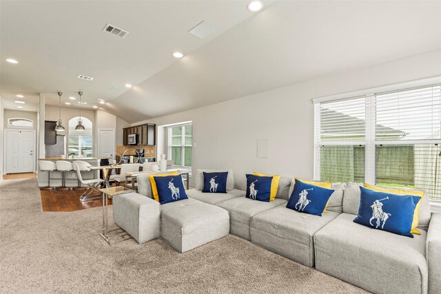 living room with plenty of natural light, recessed lighting, lofted ceiling, and wood finished floors