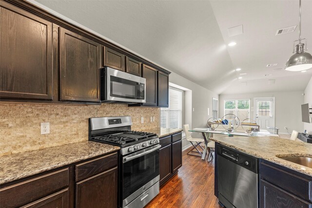 kitchen with backsplash, visible vents, appliances with stainless steel finishes, vaulted ceiling, and dark wood-type flooring