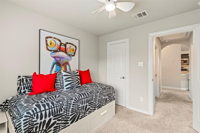 carpeted bedroom featuring baseboards, visible vents, ceiling fan, and attic access