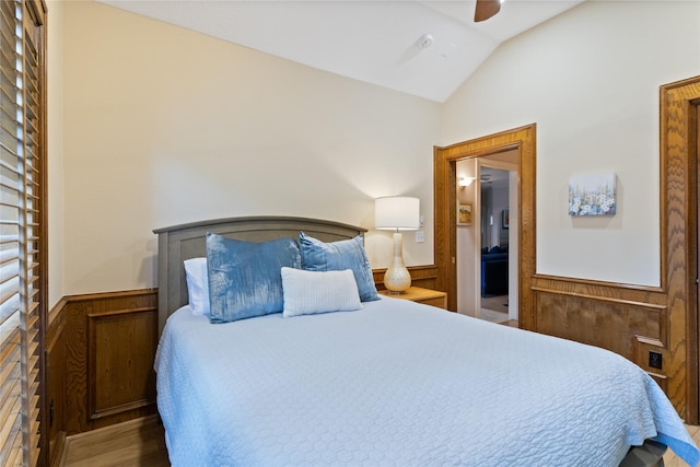 8010 Fonthill Dr, Spring, TX 77379 - bedroom with wood finished floors, wooden walls, a wainscoted wall, and vaulted ceiling