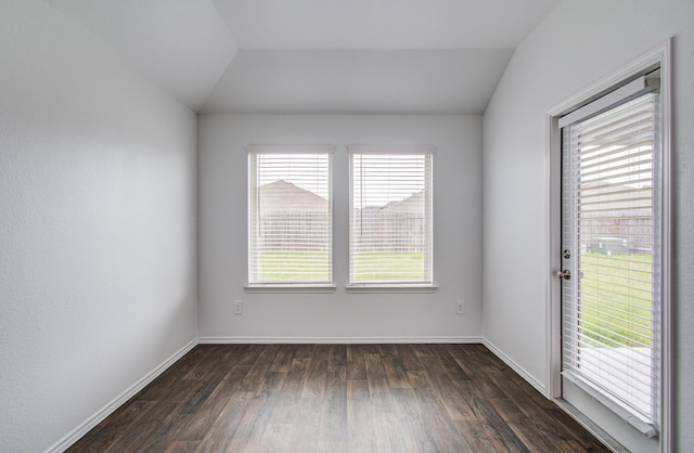 unfurnished room with baseboards, dark wood finished floors, and lofted ceiling