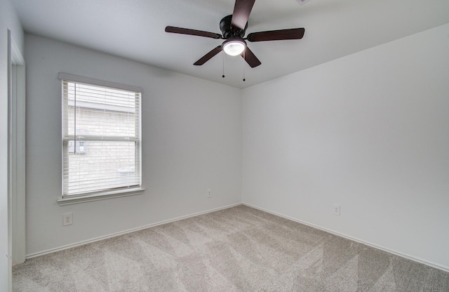 empty room featuring ceiling fan, baseboards, and carpet