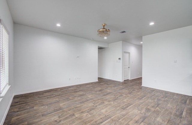 unfurnished room with visible vents, recessed lighting, baseboards, and wood finished floors