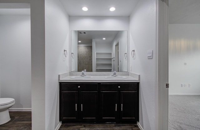 full bathroom with double vanity, toilet, visible vents, and a sink