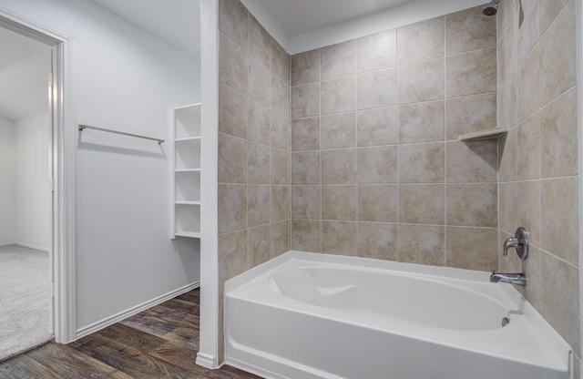 full bath with washtub / shower combination and wood finished floors