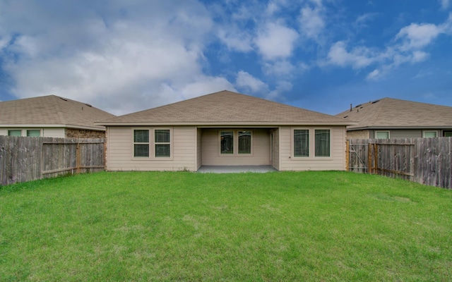 rear view of house with a yard, a patio, and a fenced backyard