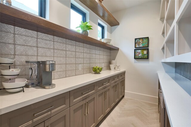 bar featuring decorative backsplash and baseboards
