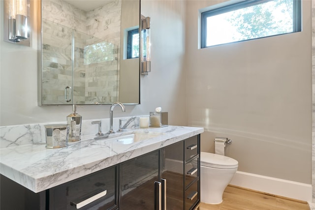 full bath featuring a shower stall, vanity, toilet, and wood finished floors