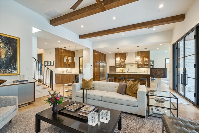 living room with stairs, beam ceiling, light wood-type flooring, visible vents, and recessed lighting