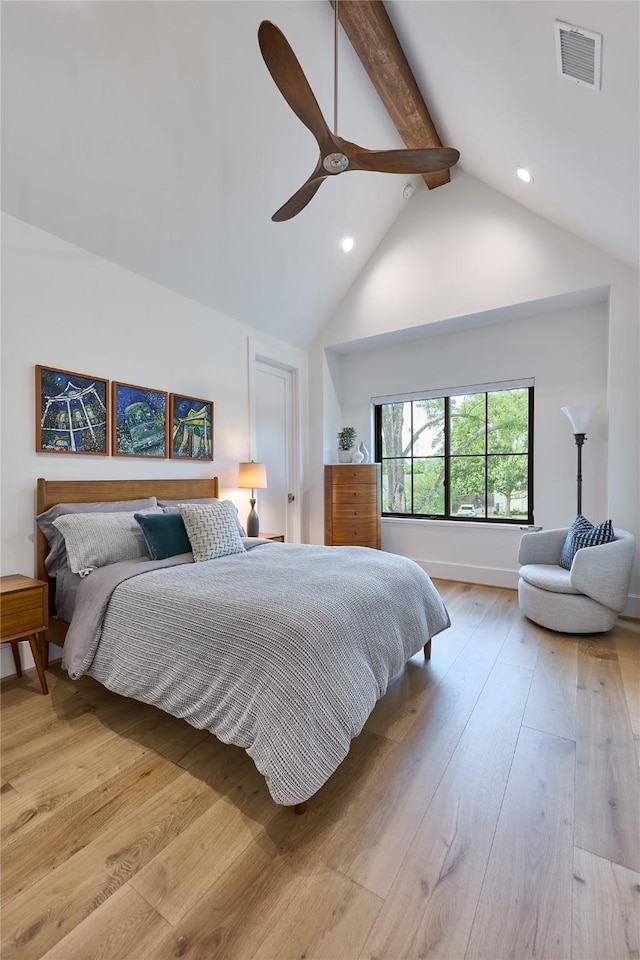 bedroom with a ceiling fan, light wood-style flooring, visible vents, high vaulted ceiling, and beam ceiling