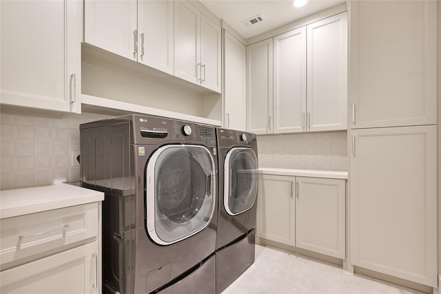 laundry room with independent washer and dryer, visible vents, and cabinet space