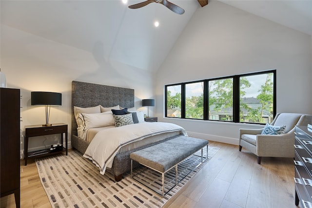 bedroom featuring light wood-style floors, a ceiling fan, beamed ceiling, and high vaulted ceiling