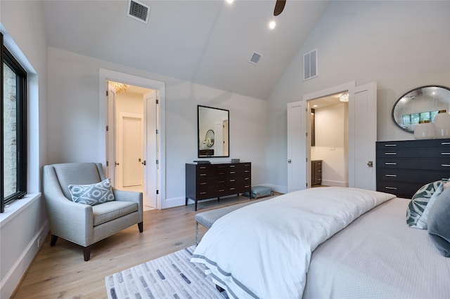 bedroom featuring visible vents, light wood-style flooring, baseboards, and high vaulted ceiling