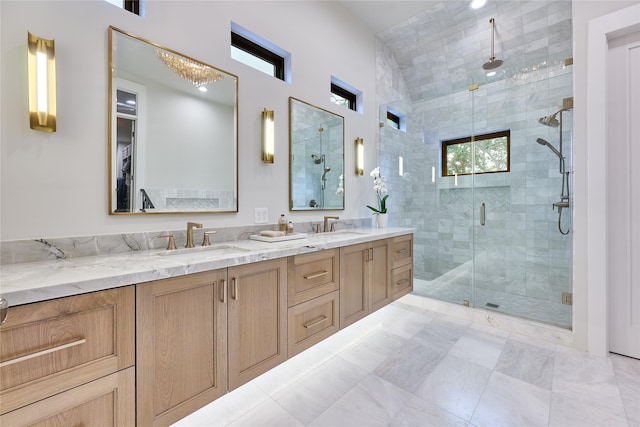 full bathroom featuring double vanity, a shower stall, and a sink