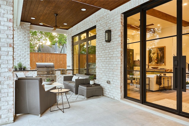 view of patio / terrace featuring fence, area for grilling, an outdoor living space, ceiling fan, and an outdoor kitchen