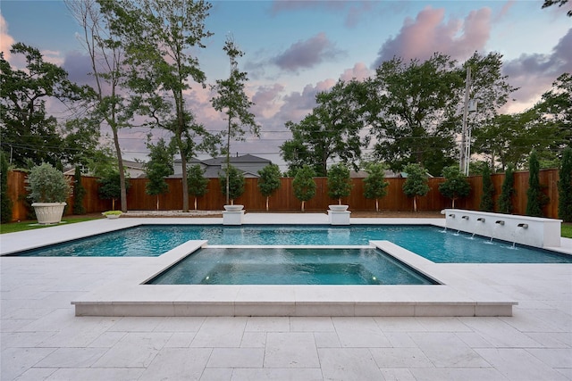 view of swimming pool with a patio area, a pool with connected hot tub, and a fenced backyard