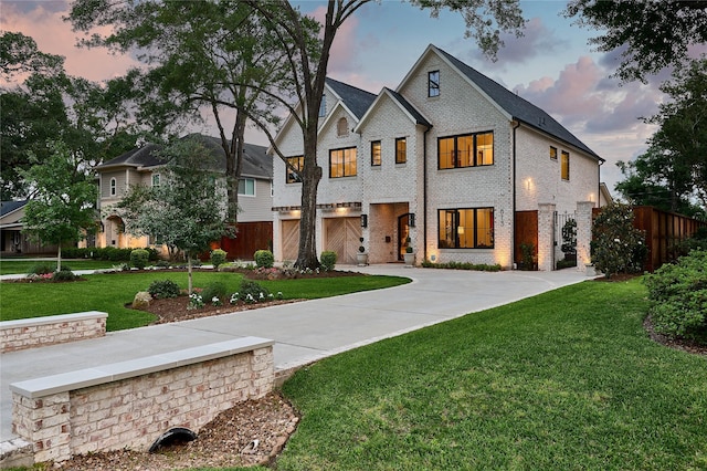view of front facade with a yard, brick siding, and fence