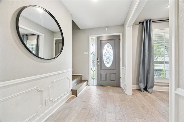 foyer featuring light wood-style flooring and stairway