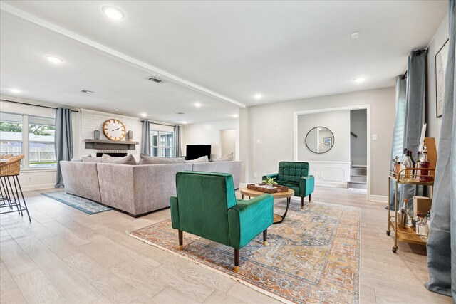 living room with recessed lighting, light wood-style flooring, a decorative wall, and a wainscoted wall