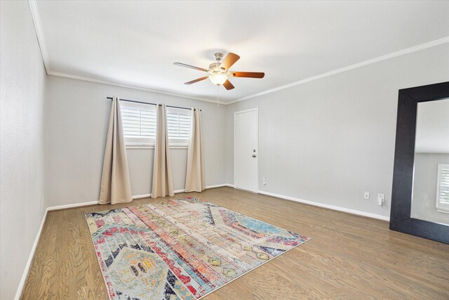 unfurnished room featuring baseboards, ornamental molding, a ceiling fan, and wood finished floors
