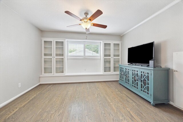 unfurnished living room with a textured ceiling, baseboards, a ceiling fan, and wood finished floors