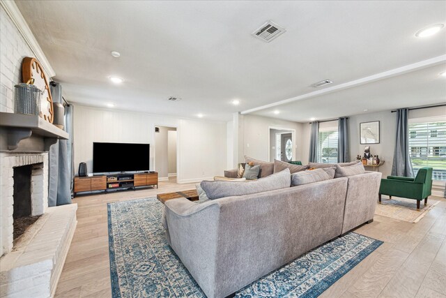 living area featuring recessed lighting, visible vents, light wood-style flooring, and a fireplace