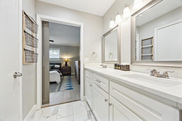 ensuite bathroom with a sink, ensuite bath, double vanity, and marble finish floor