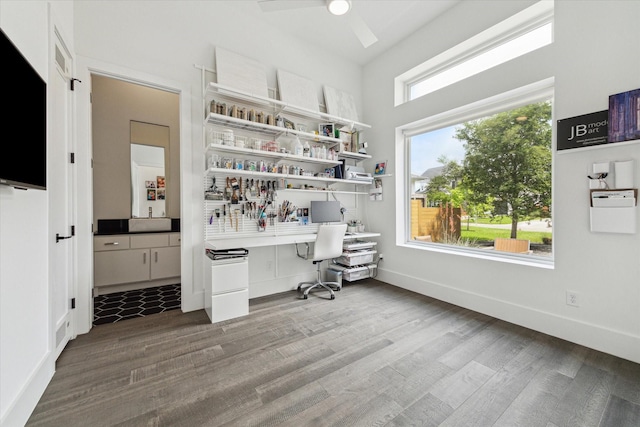 office area featuring baseboards, a ceiling fan, built in desk, and wood finished floors
