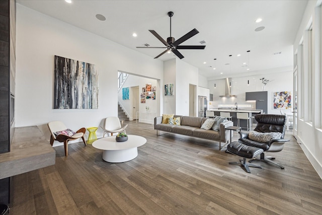living room with recessed lighting, a ceiling fan, stairs, and wood finished floors
