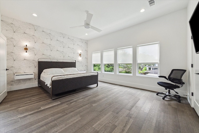 bedroom featuring recessed lighting, baseboards, wood finished floors, and an accent wall