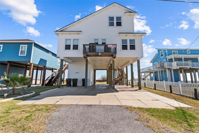 view of front facade with stairs, a carport, driveway, and a balcony