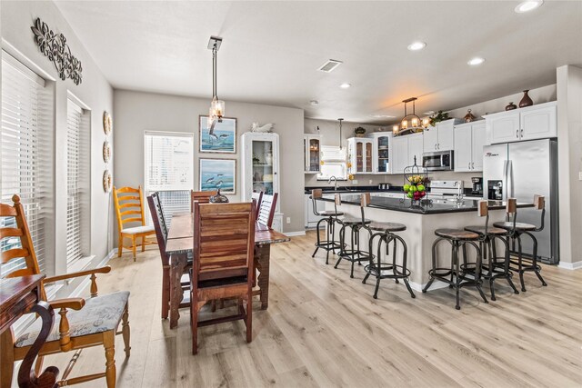 dining space with visible vents, recessed lighting, light wood-style floors, and a chandelier