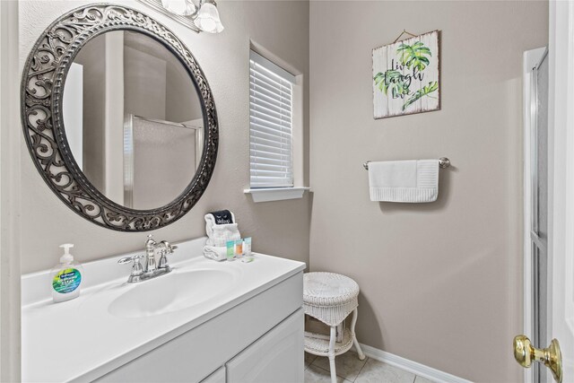 bathroom with vanity, tile patterned flooring, and baseboards