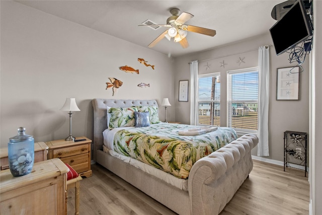bedroom featuring visible vents, a ceiling fan, light wood finished floors, and baseboards