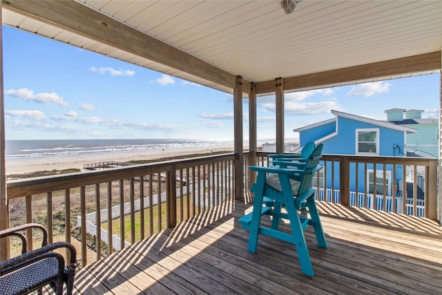 wooden terrace with a view of the beach and a water view