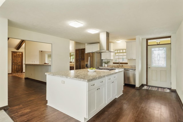 kitchen featuring dark wood-style flooring, a center island, white cabinetry, exhaust hood, and stainless steel appliances