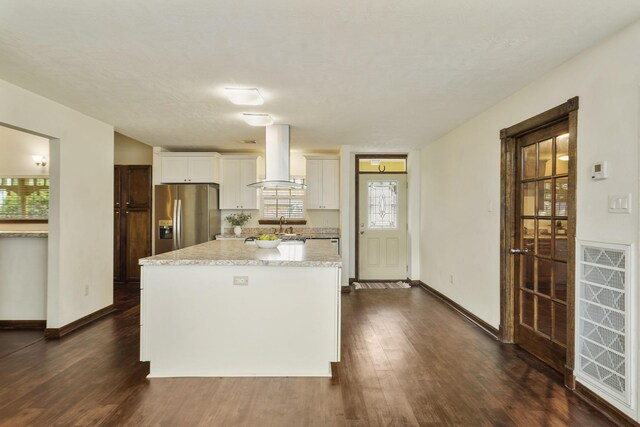 kitchen with baseboards, dark wood-style floors, a center island, stainless steel fridge with ice dispenser, and island exhaust hood