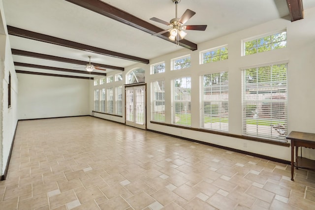 interior space featuring baseboards, ceiling fan, beamed ceiling, and stone finish flooring