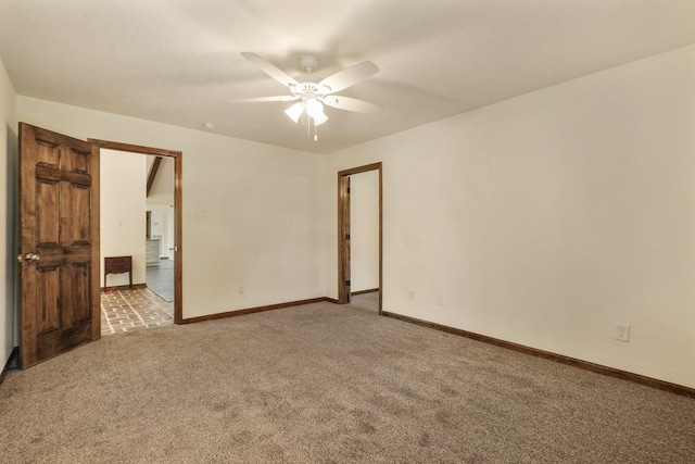 empty room featuring baseboards, ceiling fan, and light carpet