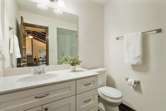 bathroom featuring vanity, a shower with door, and toilet