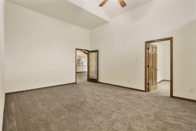 carpeted spare room featuring baseboards, ceiling fan, and high vaulted ceiling
