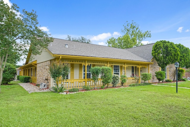 ranch-style home featuring a porch, brick siding, a shingled roof, and a front yard