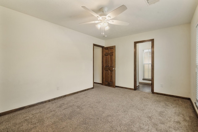 unfurnished room with baseboards, visible vents, a ceiling fan, and light colored carpet