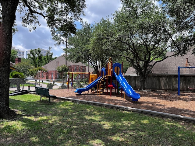 community jungle gym with fence and a yard