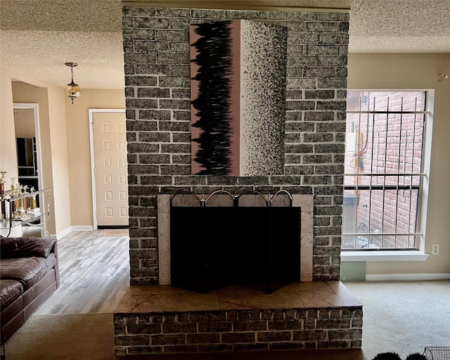 interior details with wood finished floors, a textured ceiling, baseboards, and a fireplace