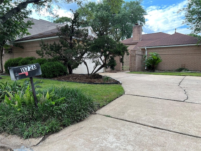 11726 Pecan Creek Dr, Houston, TX 77043 - view of front of property with brick siding, driveway, a chimney, and a shingled roof